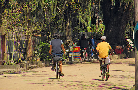 Duas pessoas andando de bicicleta pela rua
